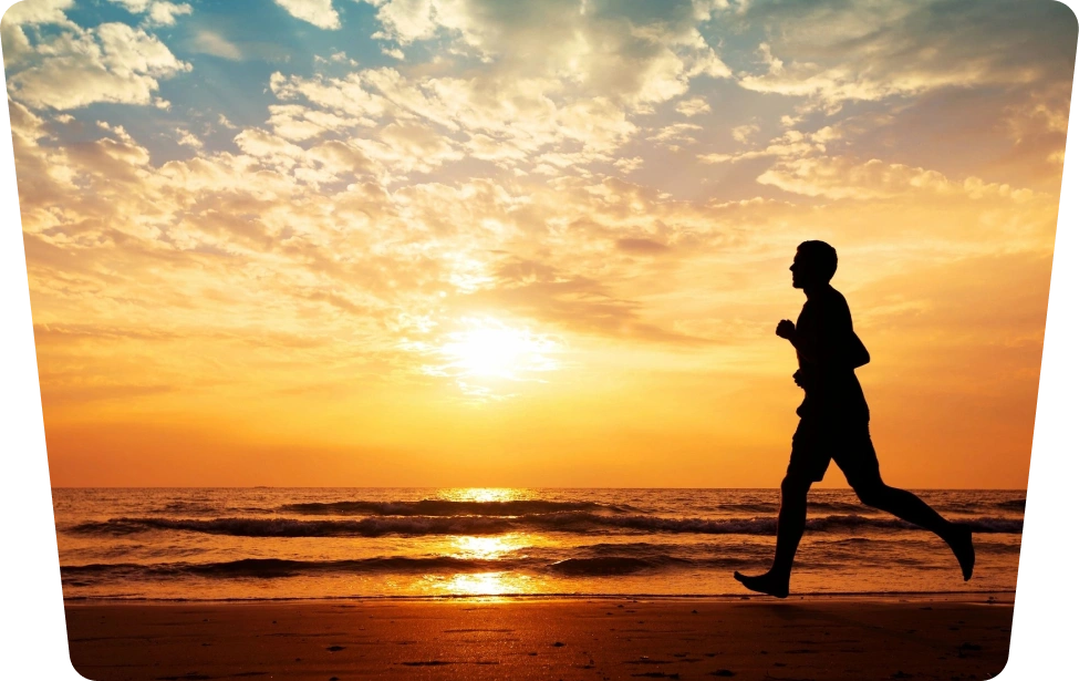hero image Silhouette of runner at sunset beach.